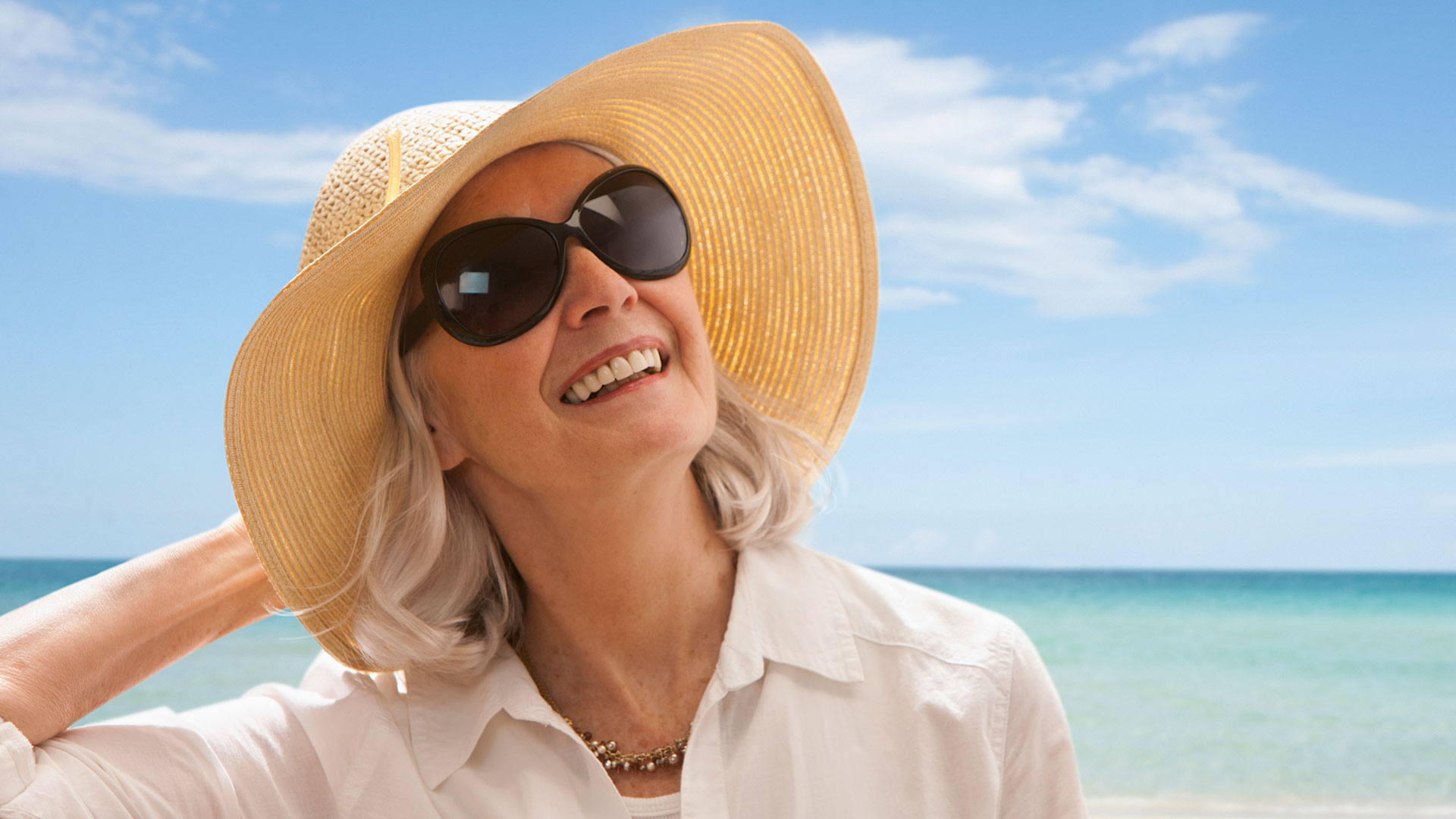 Photo of a woman on the beach wearing a hat