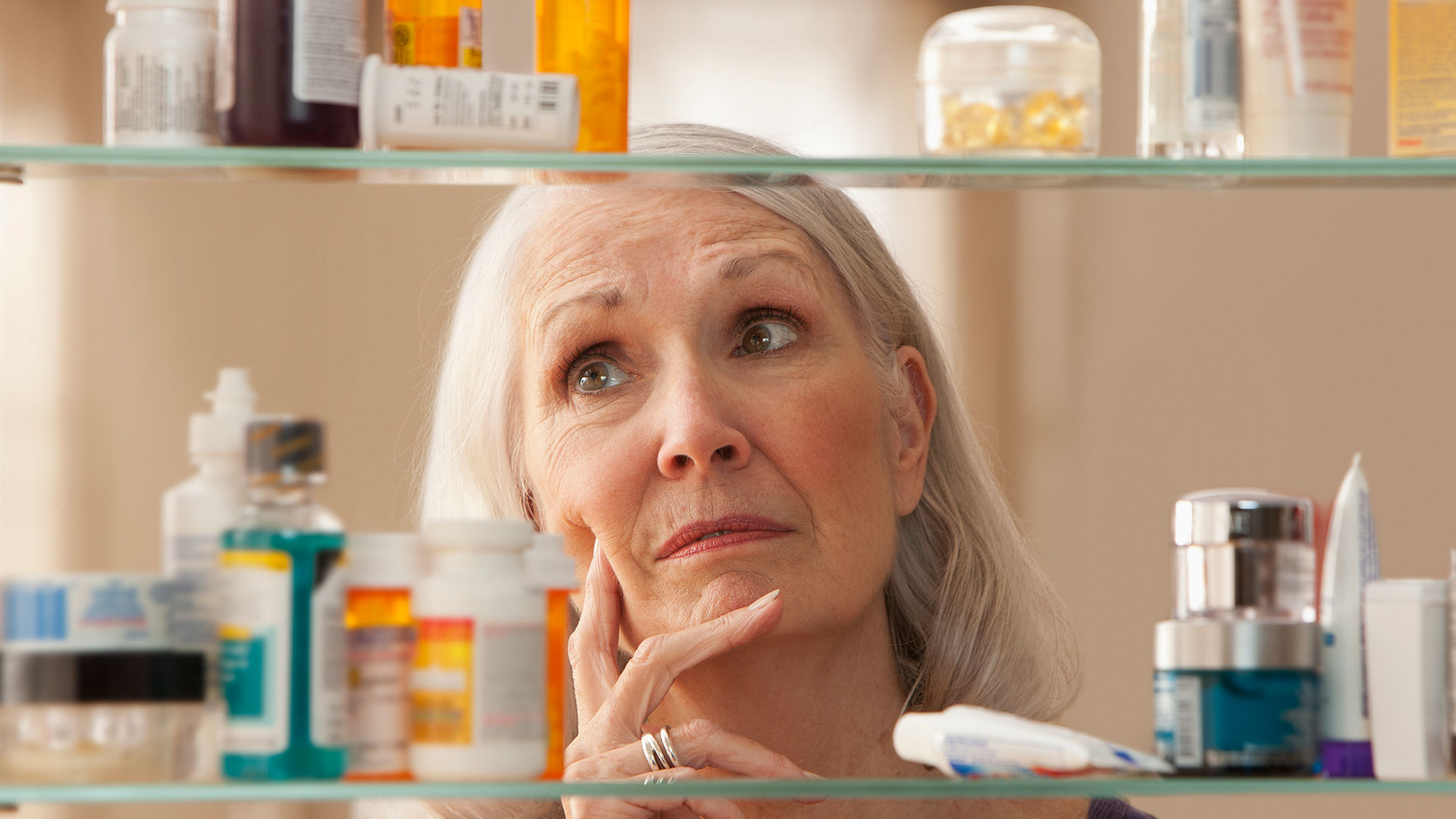 Photo of woman looking in her medicine cabinet